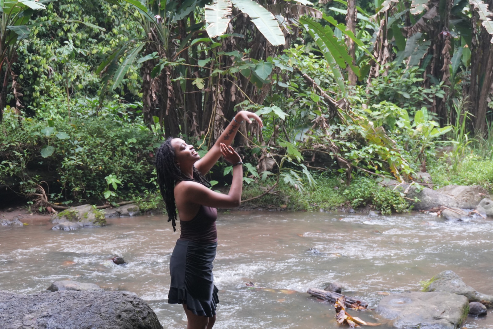 A guest in flowing movement beside a jungle stream in Costa Rica